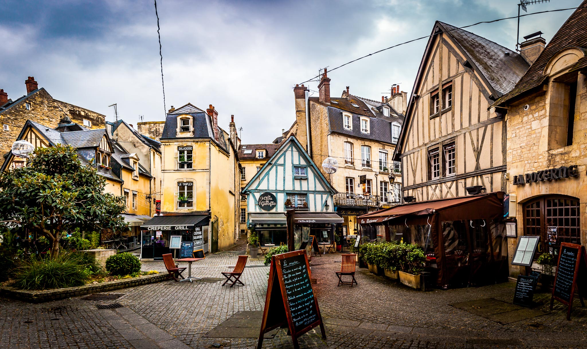 Cobbled streets and yellow and cyan half timbered houses in Caean