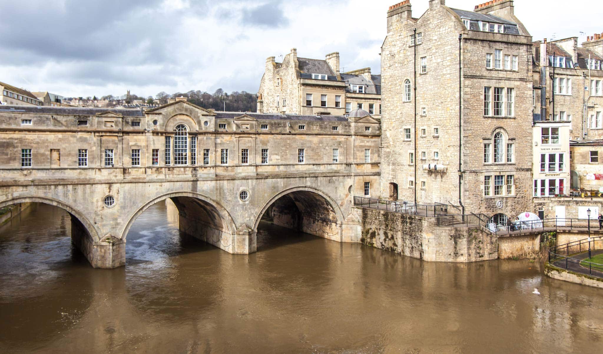 A historic bridge crosses a river in Bath, England