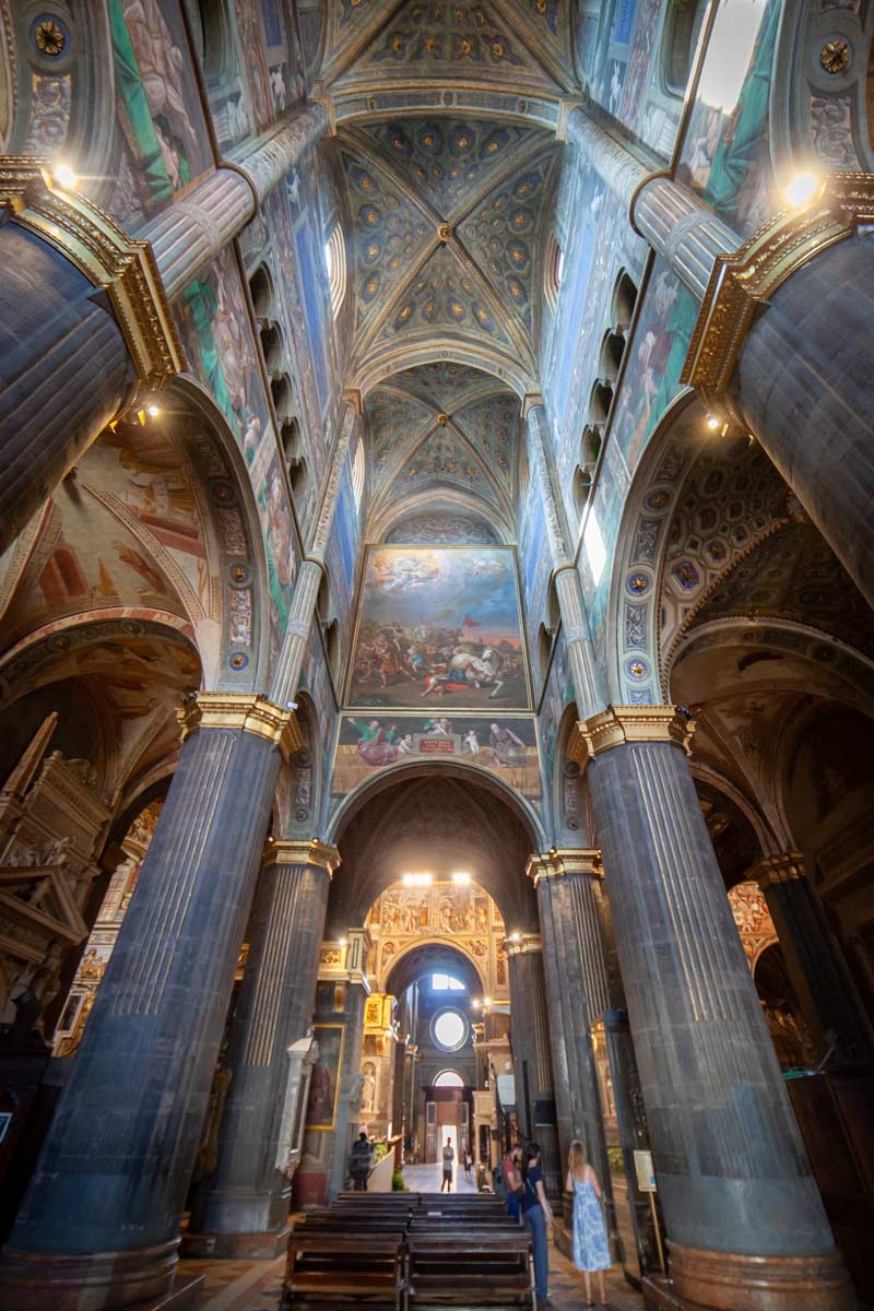 Inside Cremona Cathedral, towering pillars lead to the arched ceiling