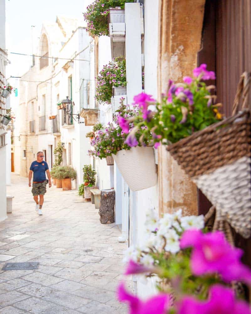 Locorotondo Puglia with white washed streets and pink flowers