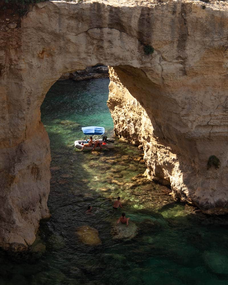 Sun comes through a cave on the Puglia coastline