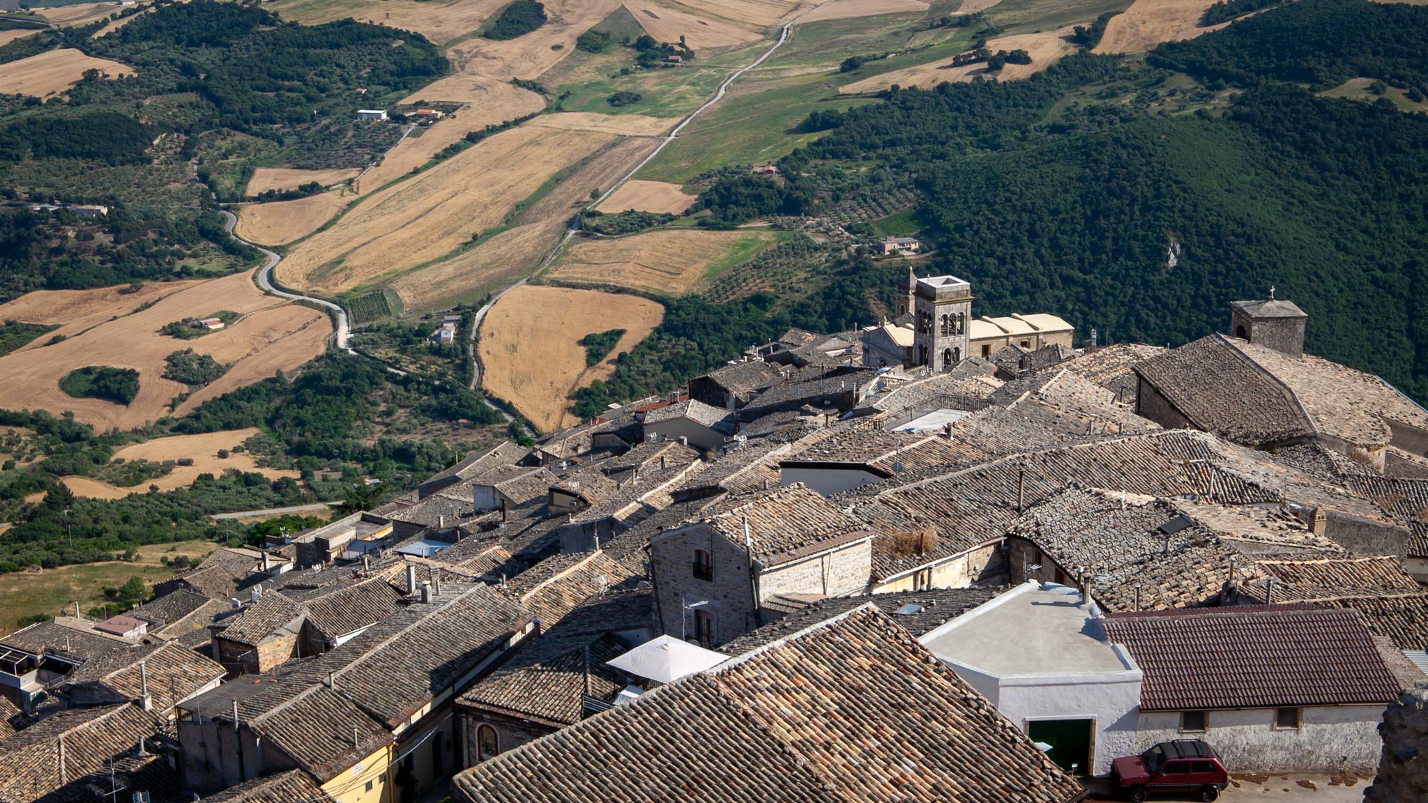 The rooftops of Sant'Agata di Puglia town with green hills in the background 