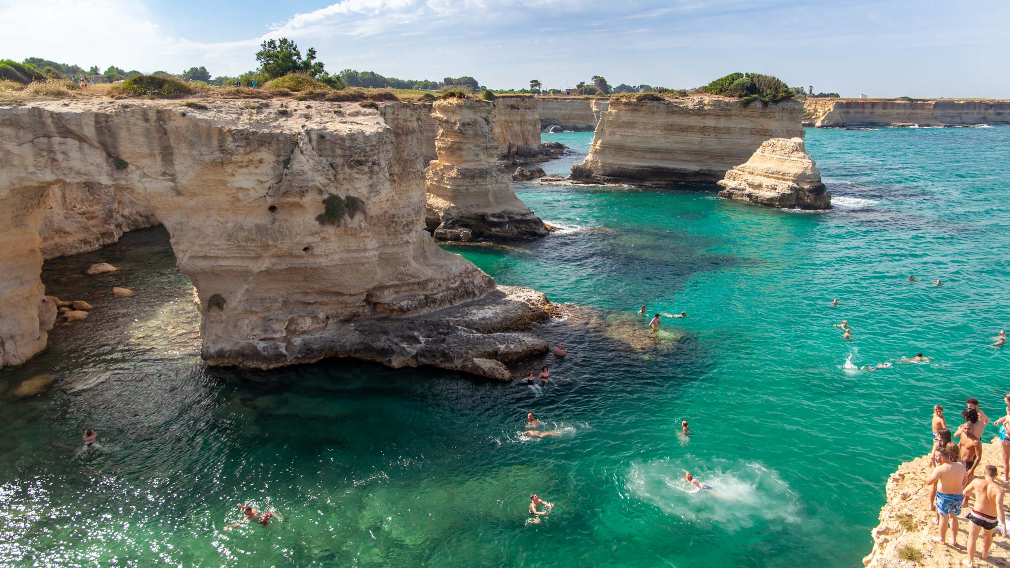 Blue hued waters crash into rocks jutting out of the Puglia coastline