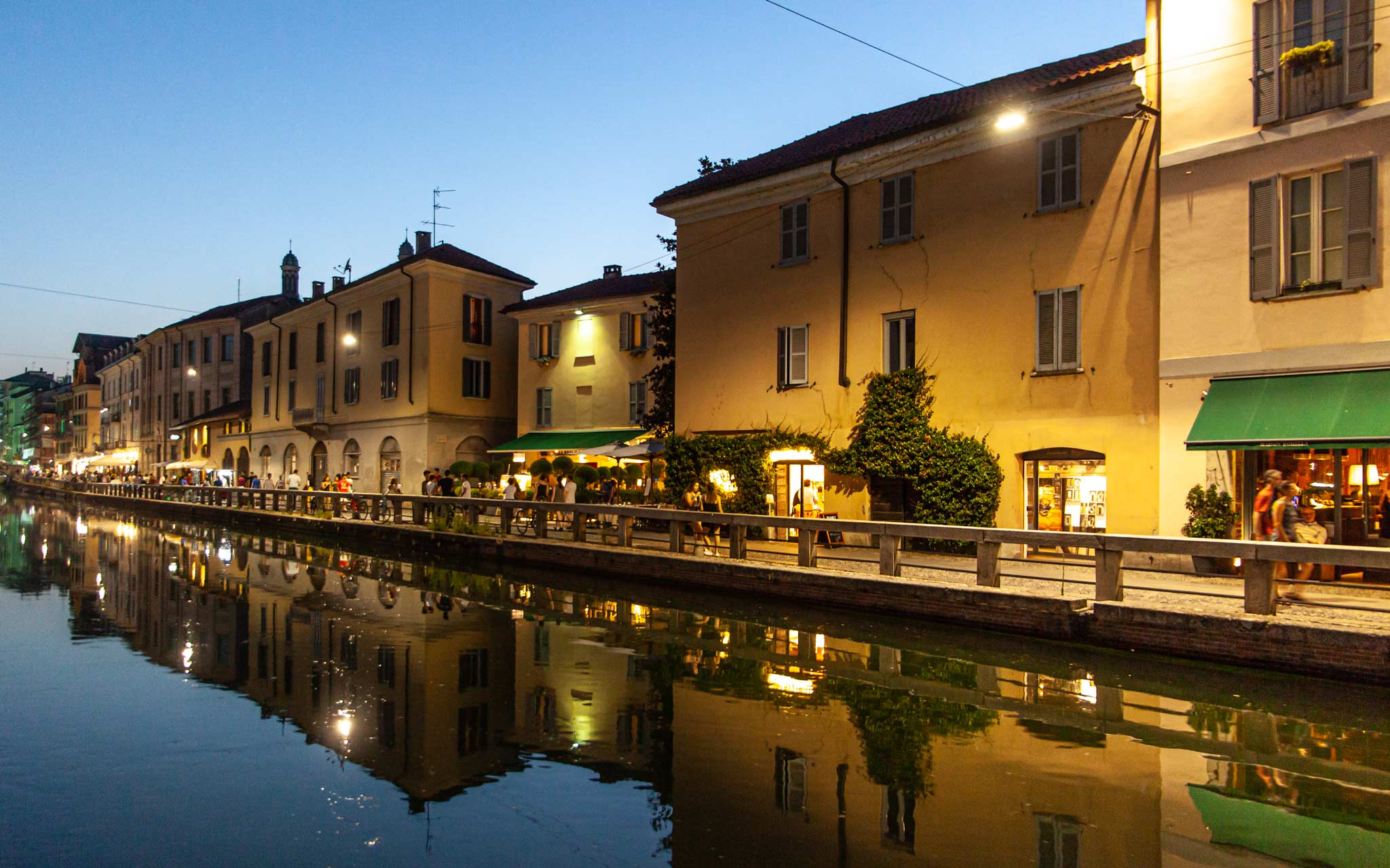 Canals reflect the shops and homes in Milan