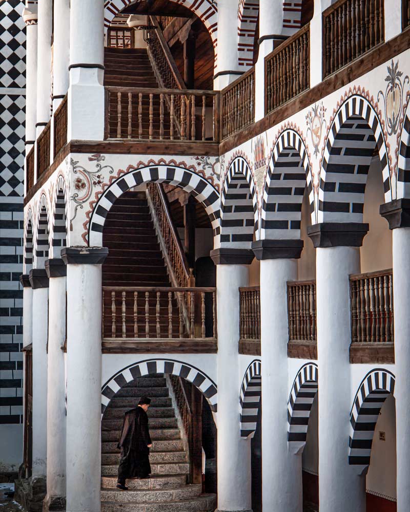 A monk climbs the stairs of Rila Monastery