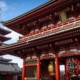 A beautiful red pagoda sits next to a large red temple in the city of Tokyo