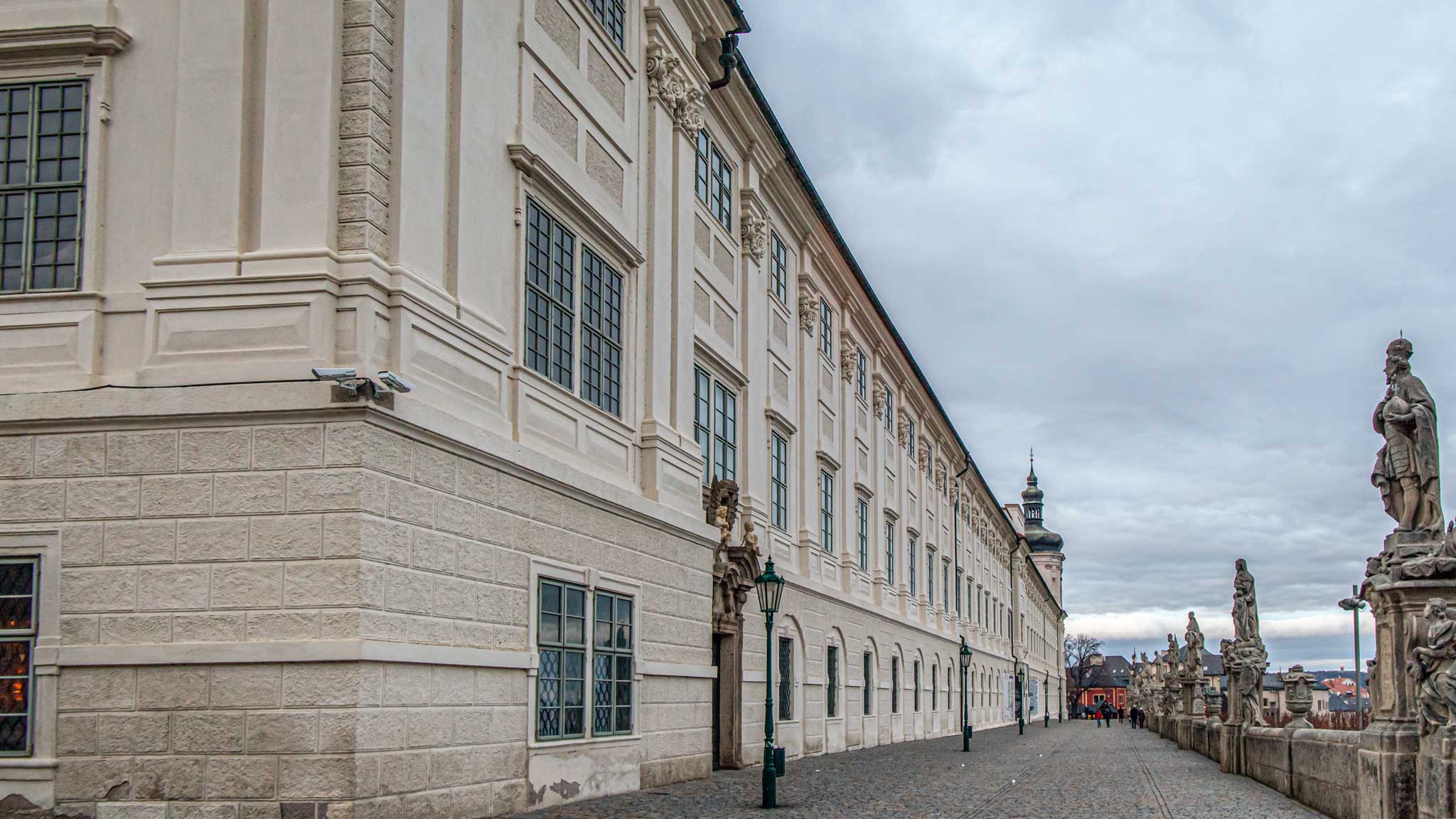 Exterior view of the Jesuit College with imposing statues on the pathway outside