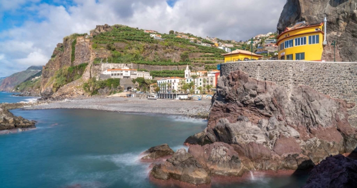 The village of Ponto do Sol in Madeira, with green hills and a small bay for swimming