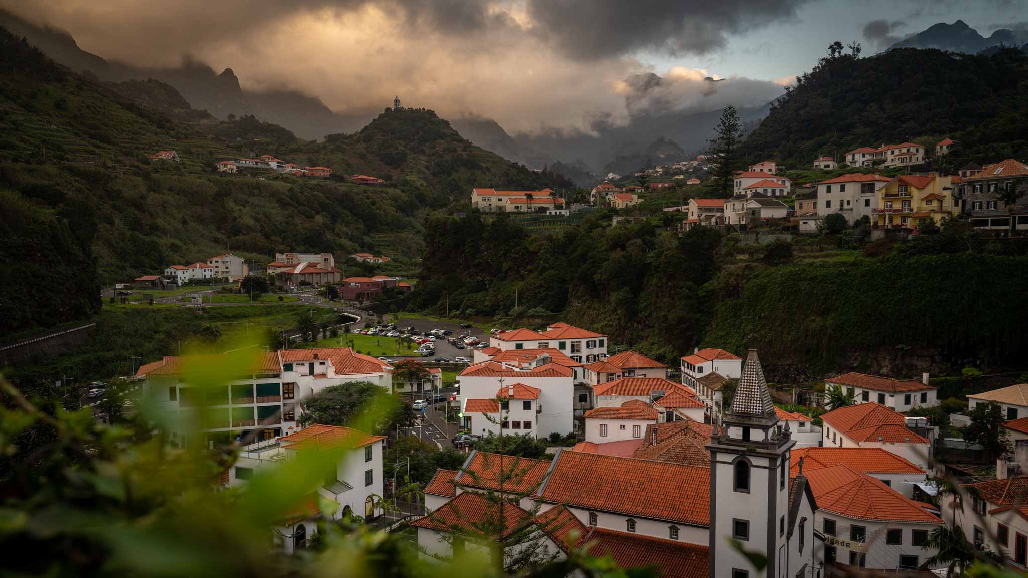 The municipality of Sao Vicente seen at sunset, with clouds floating around the mountains surrounding the town