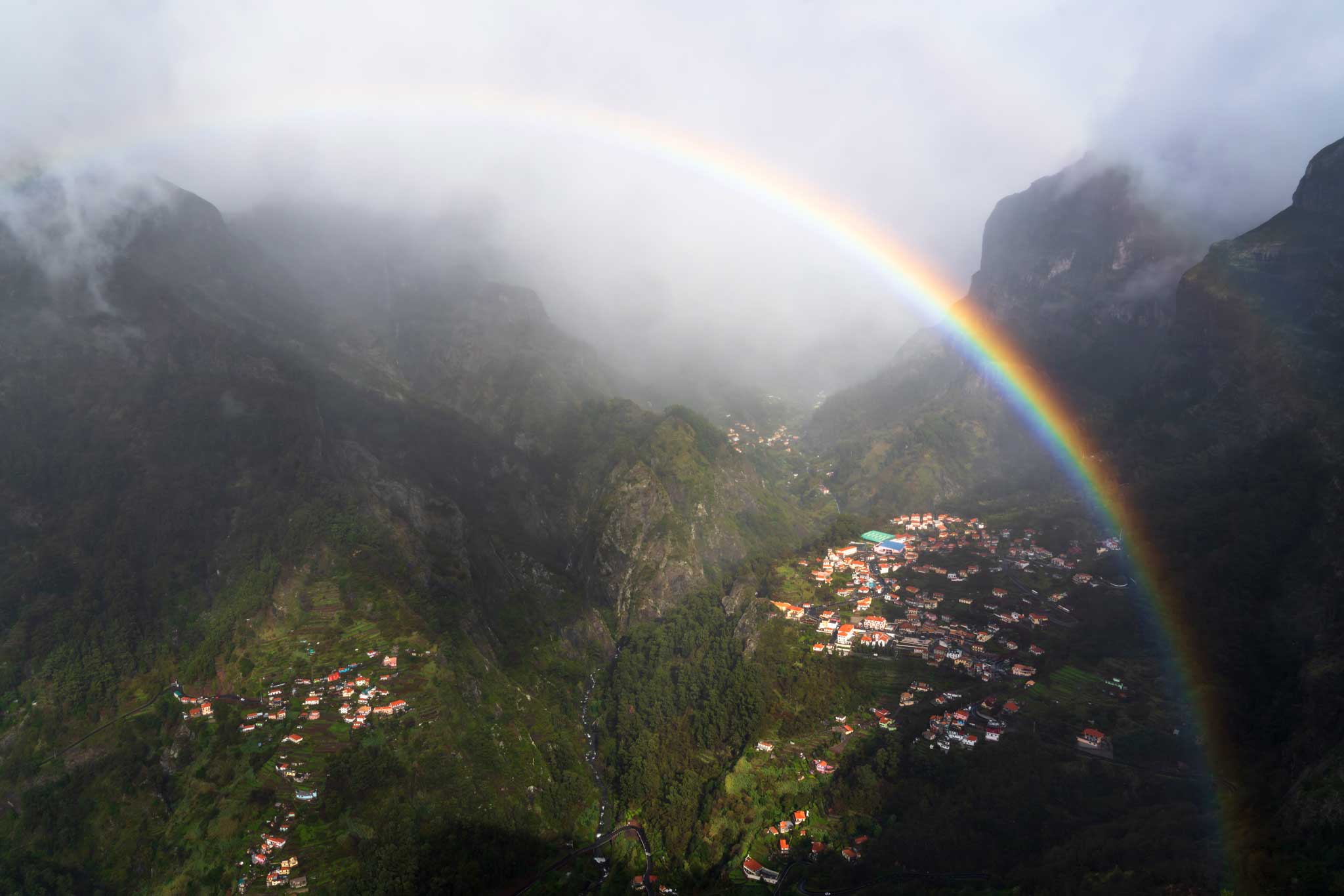 A rainbow across a mountains valley of the nuns in Madeira