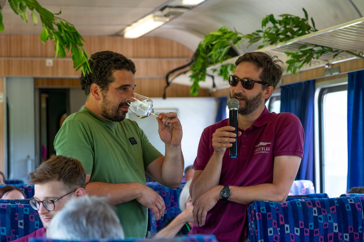 Two men present Slovenian wine tastings on a train